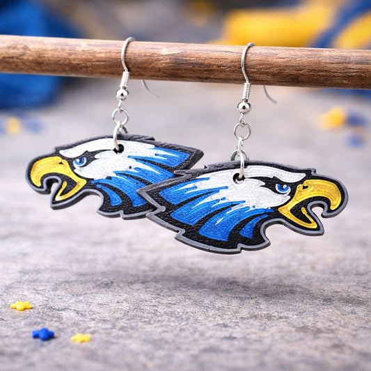 Eagle-shaped earrings on a wooden stick with a blurred background