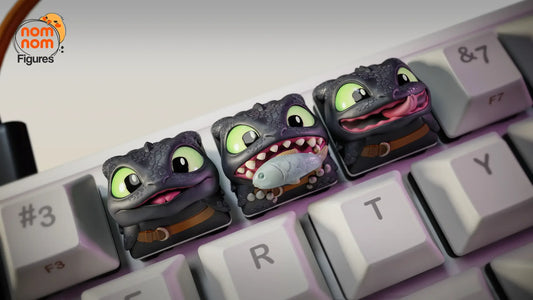 Toothless keycaps lined up on keyboard with detailed dragon faces