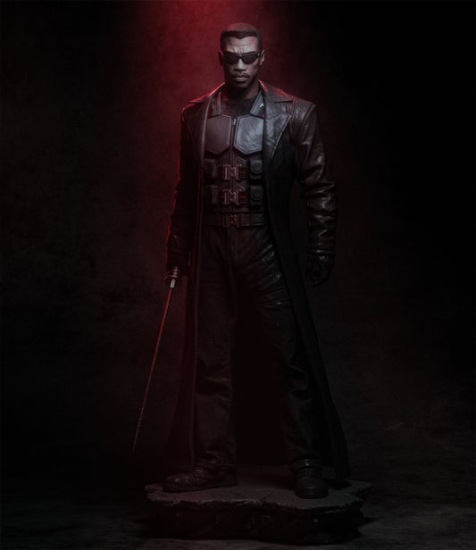 Statue of a character in a dark outfit with a red light, set against a dark background