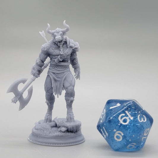 3D printed resin Minotaur miniature with greataxe shown next to a blue d20 for 32mm scale reference.