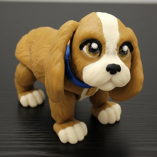 Articulated cocker spaniel fidget toy shown in warm tan brown with creamy white markings and a blue collar. Available in single color or multi color options. Fully posable, custom colors available, perfect for desk decor, sensory play, or gifting.
