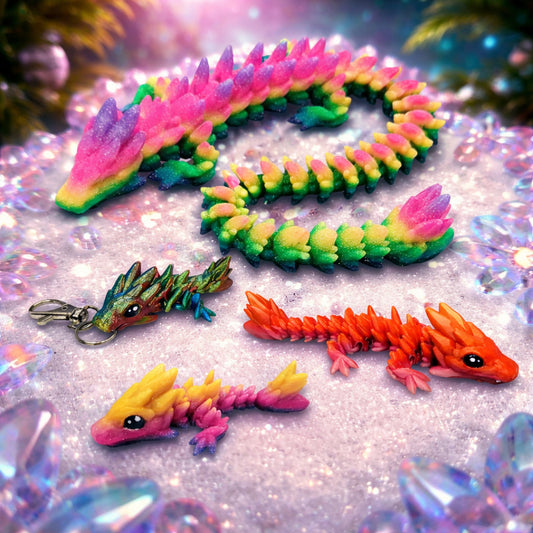Colorful articulated gemstone dragon toys with crystal scale textures displayed on a bright fantasy style background, flexible dragon figures in multiple sizes and colors.