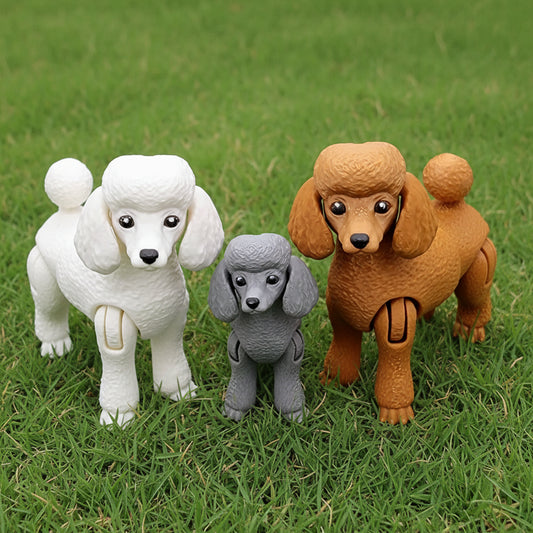 Three articulated 3D printed Poodle dog toys in white, gray, and apricot colors with movable joints and detailed features on grass.