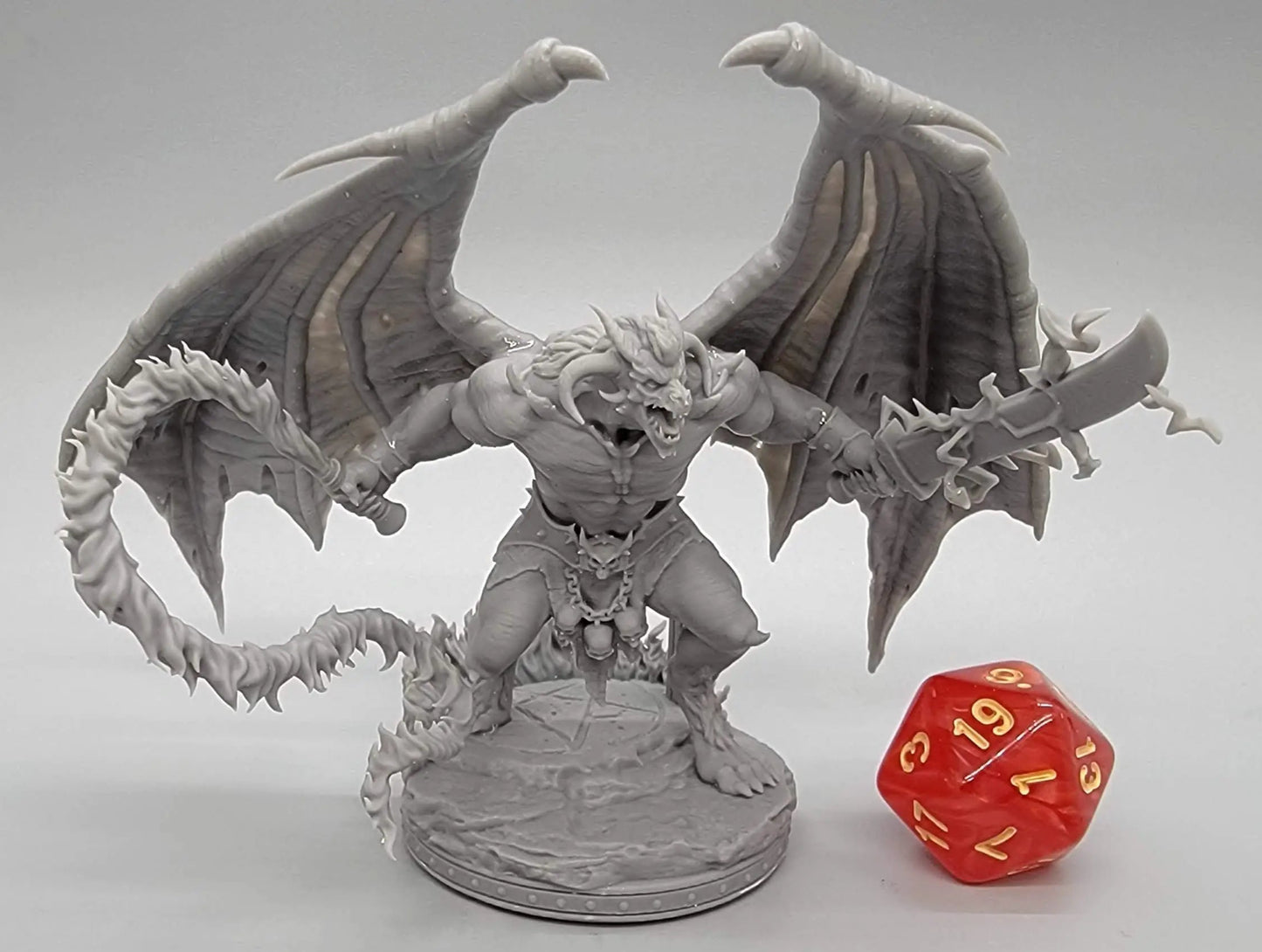 Resin-printed Balor Vogron demon miniature with wings, swords, and flame tail next to D20 die – 32mm or 75mm scale boss for DnD, Pathfinder, and TTRPG display