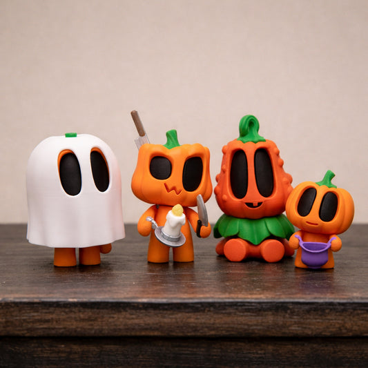 Set of cute blob pumpkin character toys displayed on a wooden surface with a neutral background