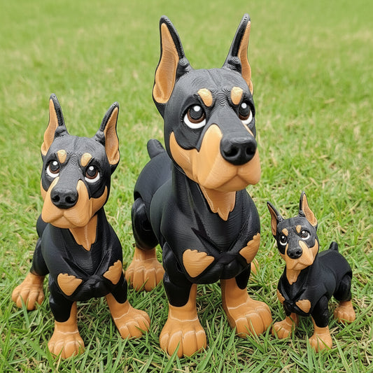 Three articulated chibi Doberman dog toys in small, medium, and big sizes displayed on grass, showing tri-color finish with poseable heads and legs, 3D printed fidget toys for dog lovers