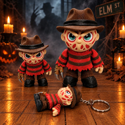 Chibi Freddy Krueger articulated figures in red-and-brown striped sweaters and brown hats, with two standing toys and a keychain figure lying on a candlelit set.