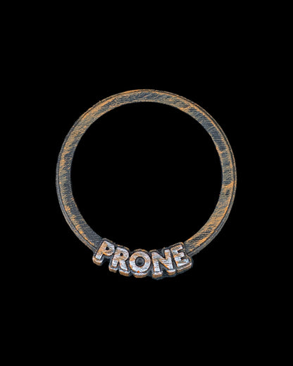 Close-up of orange and black "PRONE" ring for D&D miniatures, made from durable 3D printed plastic.