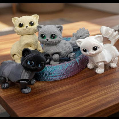 Flexi munchkin cat fidget toys shown in soft cream, light gray, charcoal black, and bright white with large glossy eyes. Fully articulated and posable, with optional textured cat bed or cozy cat house. Custom colors available. Perfect for desk decor, sensory play, or gifting.