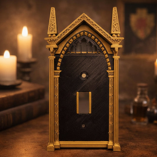 Bronze and black HP inspired light switch cover designed like a gothic wizard arch, on a wood tabletop, soft candlelight, and blurred decor in the background for a cozy magical aesthetic
