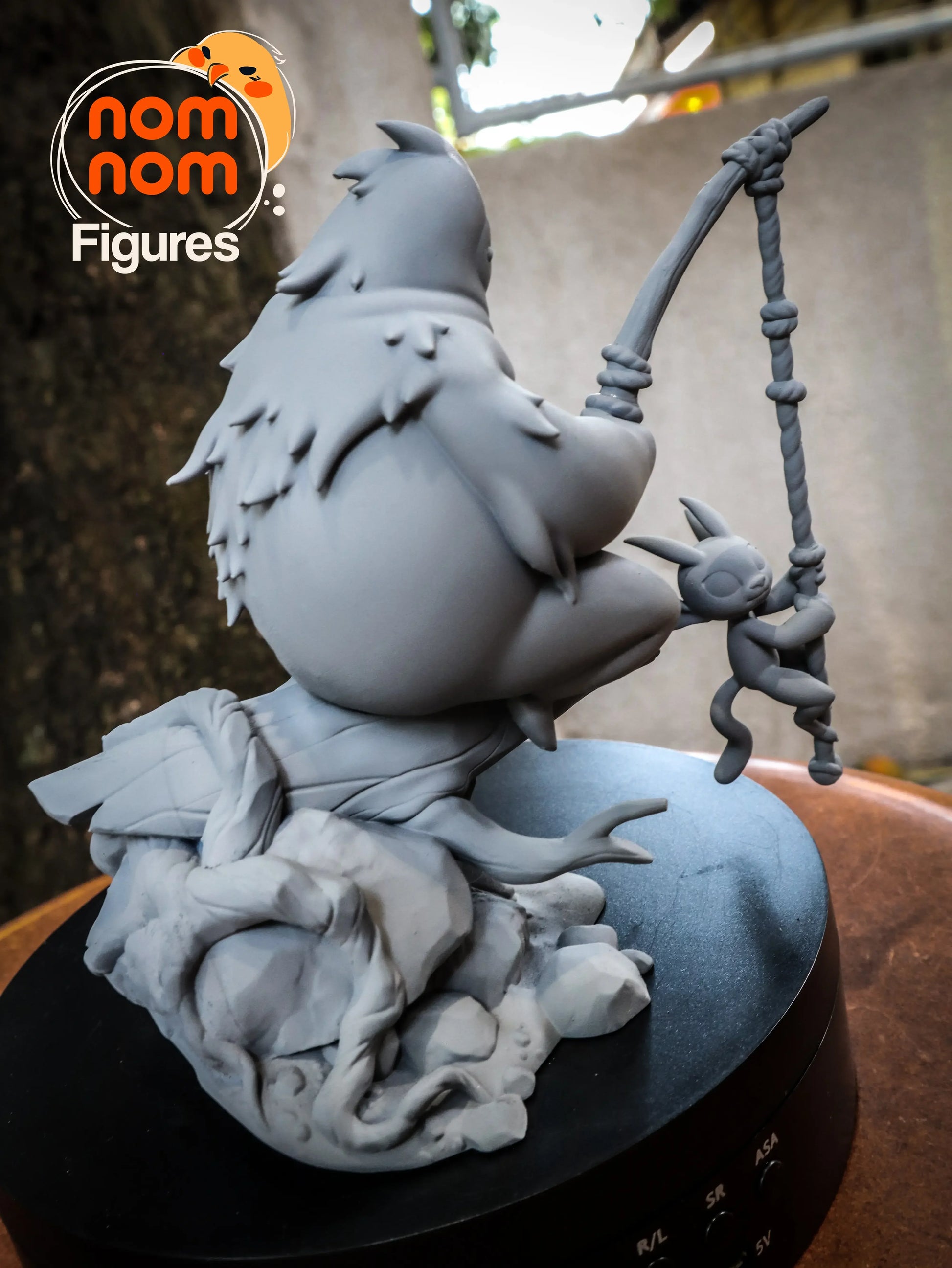 Close-up of Nom Nom Figures Chibi Scale Fishing Creature statue, showing fishing rod and rope details.