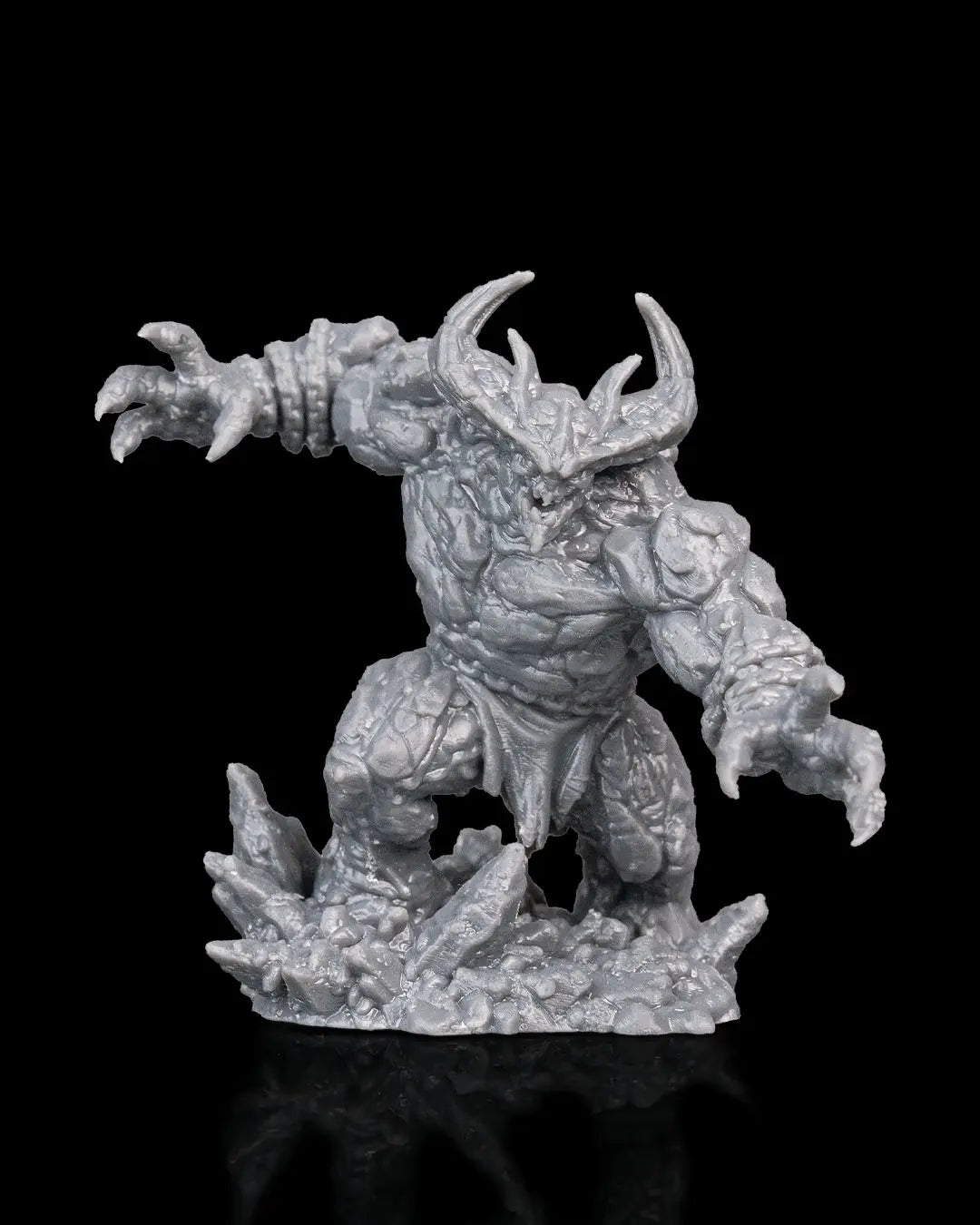 Gray resin magma golem fantasy figurine with horns on a black background