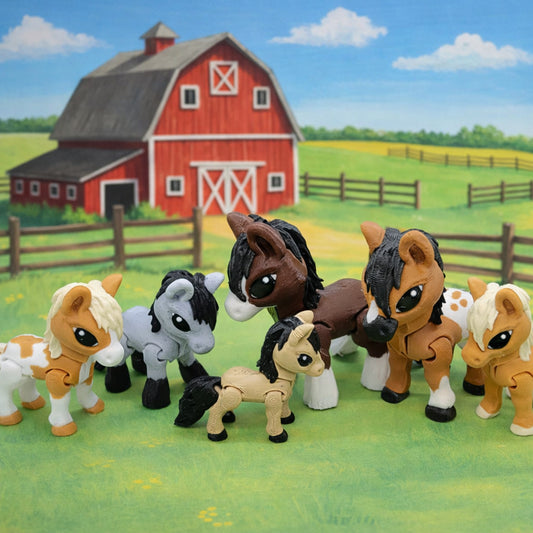 Six articulated mini horse toys colored like different breeds of horses standing on green grass in front of a red barn and fenced pasture background.