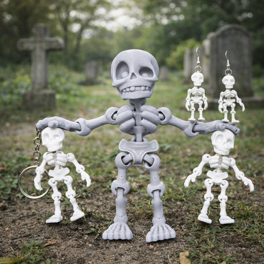Articulated light gray skeleton toy standing on grass in a cemetery scene, holding small white skeleton figures including a skeleton keychain and white skeleton earrings, with gray stone tombstones and green foliage softly blurred in the background