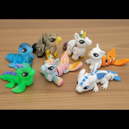 Colorful mythical hatchling toys displayed on a wooden surface, including small dragons, unicorns, and fantasy creatures in blue, green, white, pink, orange, and multicolor finishes.