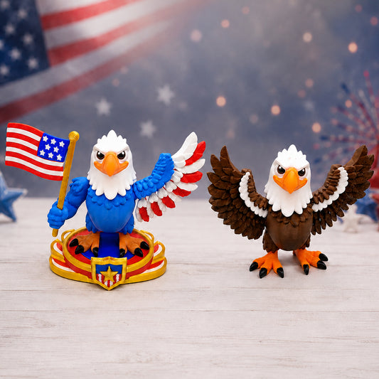 Two 3D printed bald eagle figurines side by side — Patriotic Blue Eagle holding a US flag on a patriotic display stand, and Natural Brown Eagle with wings spread wide. Made in the USA.
