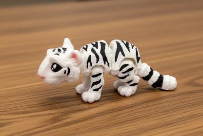 white and black mini tiger toy on a wood surface