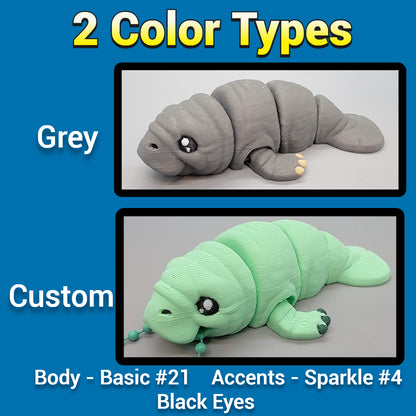 Two manatee toys, one gray and one custom green with black eyes, on a blue background.