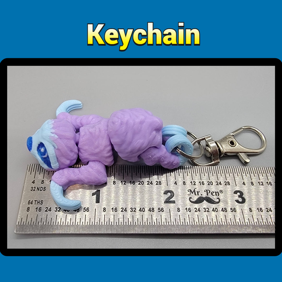 Purple and blue keychain with a ruler for scale on a gray background