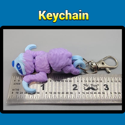 Purple and blue keychain with a ruler for scale on a gray background