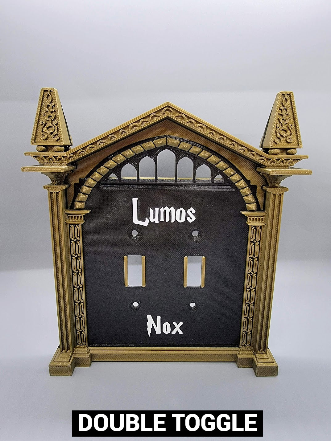 Double toggle wizard light switch cover with custom Lumos and Nox white lettering and bronze frame