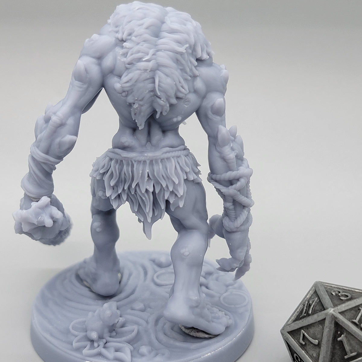 Rear view of unpainted Hag Cursed Troll 1 showing textured hair, muscular back, clothing, and wooden club.