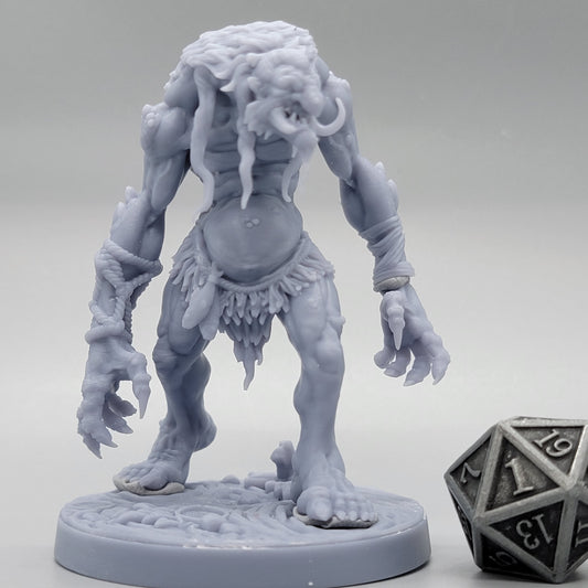 Unpainted Hag Cursed Troll 1 with empty hands, long tusks, and a round scenic base beside a metal d20.