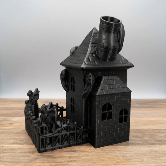 Front perspective view of the black 3D printed PLA+ Haunted House dice tower showing the chimney top and graveyard fence dice tray.