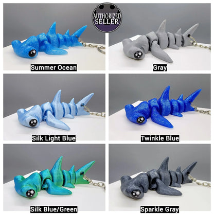 Hammerhead keychains colored in Summer Ocean, Gray, Silk Light Blue, Twinkle Blue, Silk Blue/Green, and Sparkle Gray.