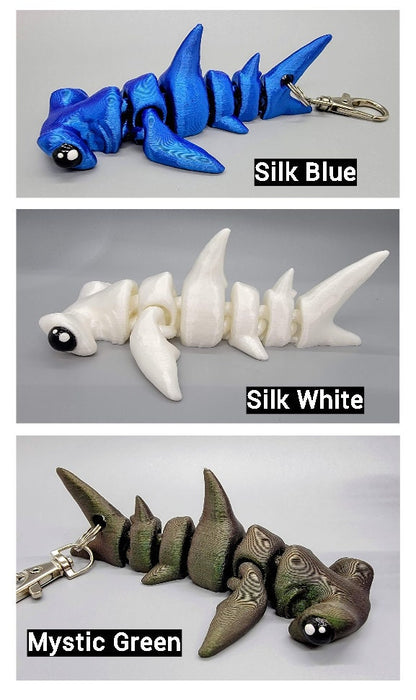 Hammerhead keychains colored in Silk Blue, Silk White, and Mystic Green.