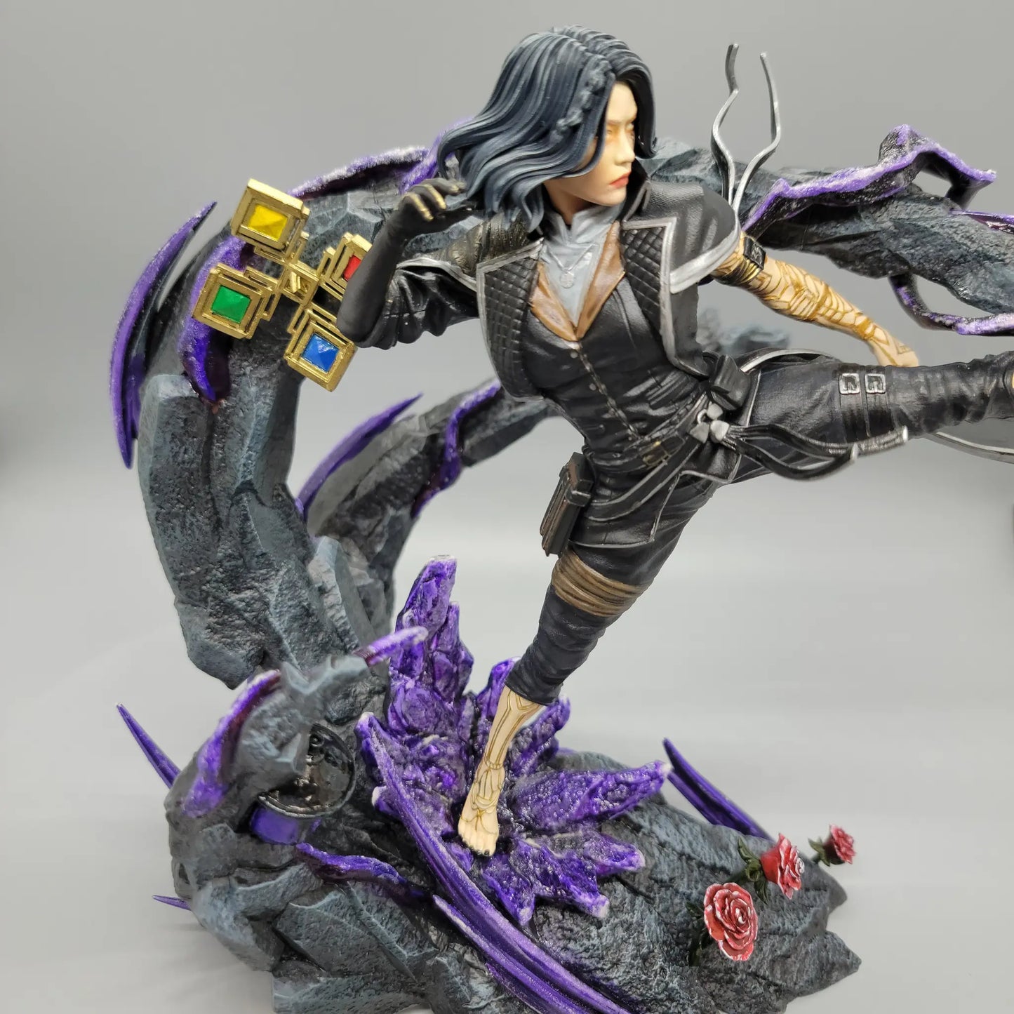 Close angle of hand painted Lune resin statue showing face, outfit, base, and purple details
