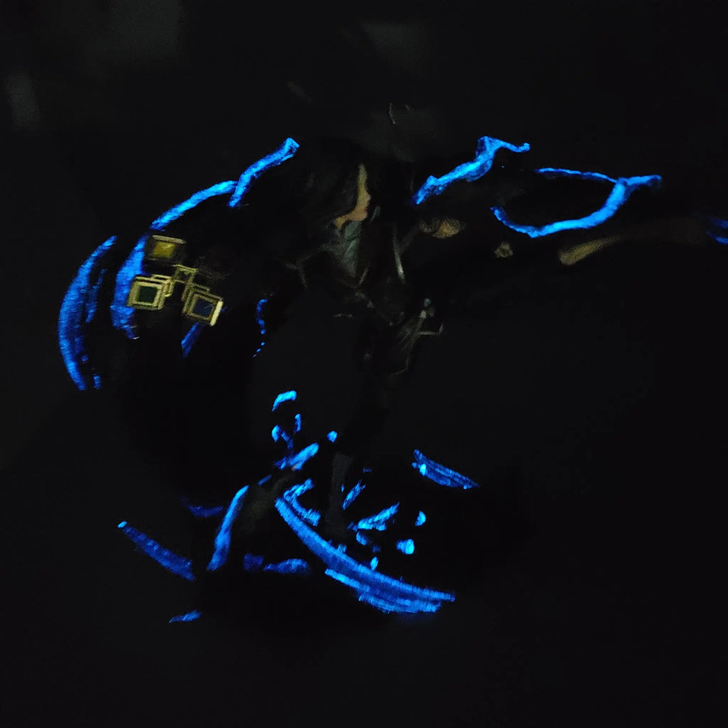 Dark glow photo showing purple and blue glowing details on painted Lune resin statue
