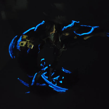 Dark glow photo showing purple and blue glowing details on painted Lune resin statue