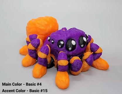 3D-printed spider toy with purple and orange colors on a gray background