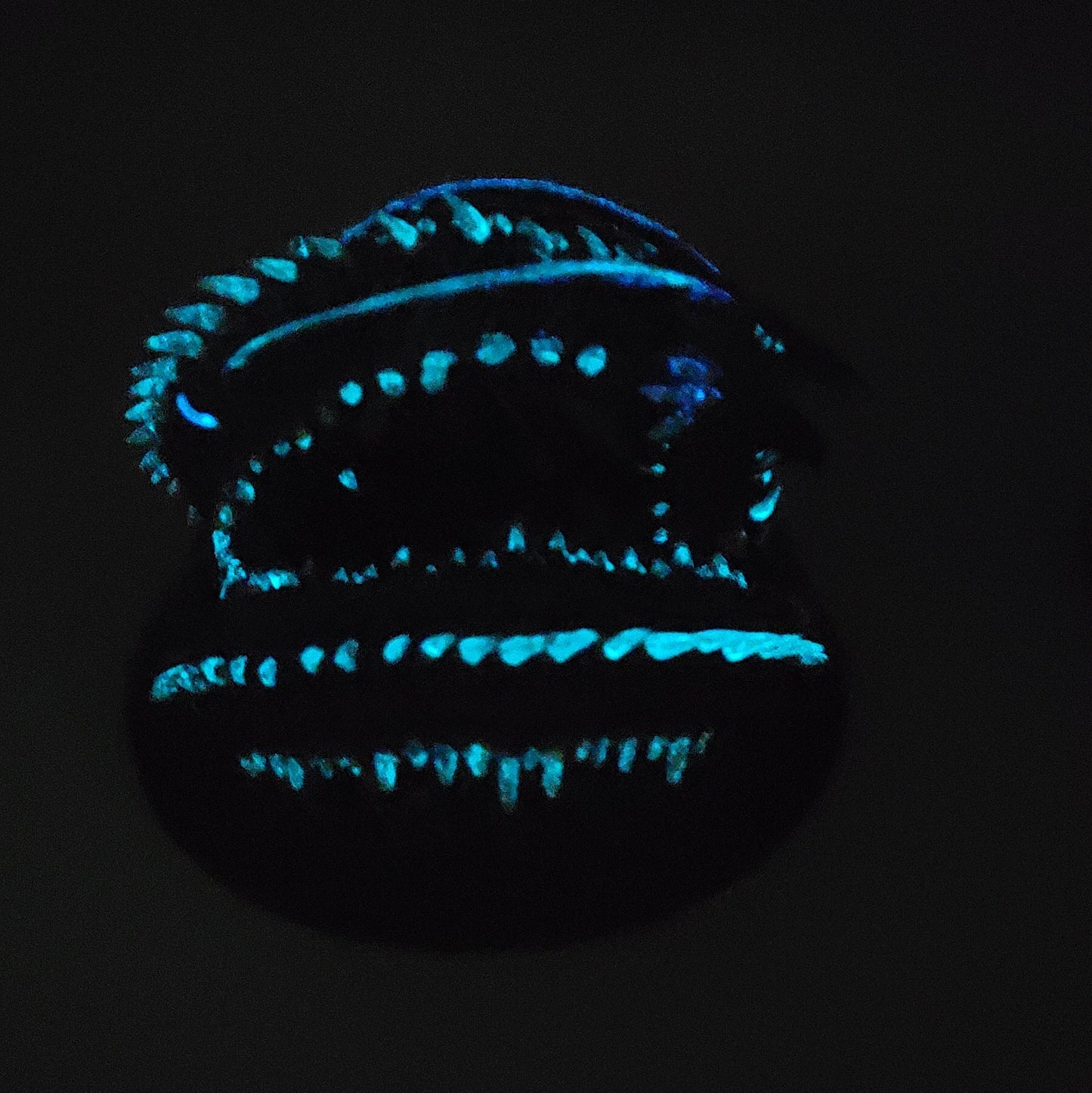 Glow effect photo of Old Mawgrin sea serpent miniature showing blue glowing details in the dark