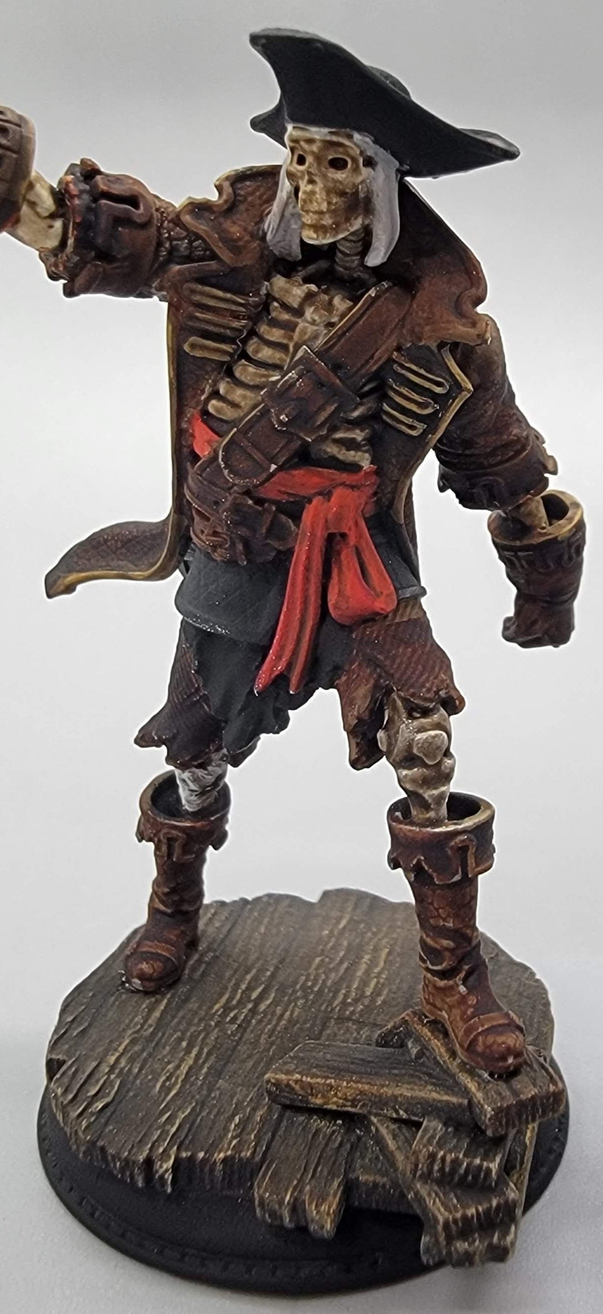 Front view of painted pirate skeleton resin miniature with cutlass and dock base for TTRPG games