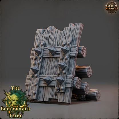 Thumper Board scatter terrain prop made from rough wooden planks, stacked logs, rope bindings, and metal spikes.