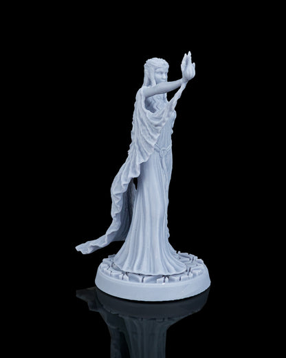 Right side profile view of the Valyra elven miniature, emphasizing the forward stretch of her spellcasting arm and the elegant folds of her long flowing gown.