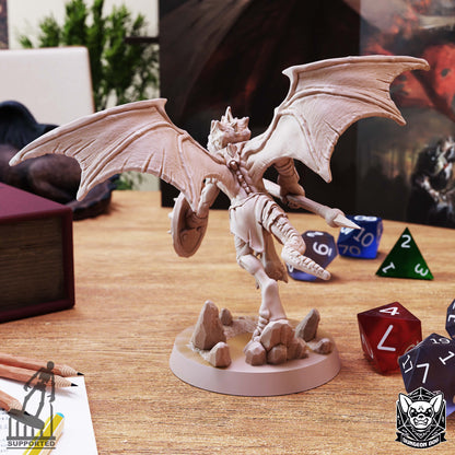 Rear view of Winged Kobold Spear miniature showing its textured dragon wings, reptilian tail, and rocky base.